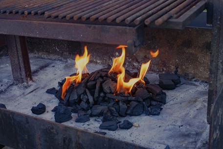Charcoal fire lighting in a professional outdoor grill at Dublin Cookery School BBQ class