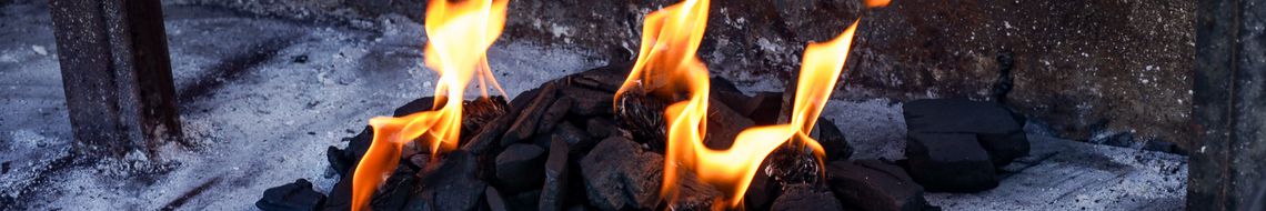 Charcoal burning in a grill, orange flames rising from lit coals — Summer BBQ Feast at Dublin Cookery School
