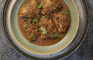 Dublin Cookery School gift voucher displayed on a wooden breakfast tray alongside fresh tulips, coffee, and a croissant, representing the gift of a lifelong skill.