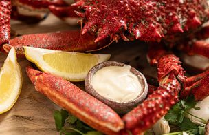 A whole cooked crab on a wooden board with lemon wedges, grilled bread, samphire and butter — a shellfish spread from Dublin Cookery School's Fish & Shellfish Workshop.