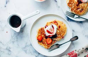 Overhead flat lay of salmon blinis on a slate board, tomato soup with cream swirl, sesame chicken udon noodles and chipotle beef lettuce cups on a wooden surface, Dublin Cookery School Growing Gourmets Junior Summer Camp