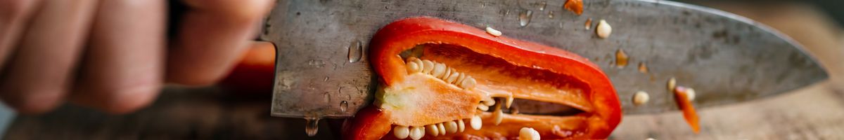Red pepper being expertly chopped with a chef's knife