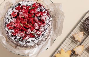 Freshly baked cake topped with strawberries and dusted with icing sugar